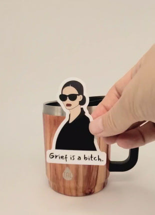 Video of applying high quality dishwasher safe sticker on to-go mug. "Grief is a bitch" by Deathday Cards