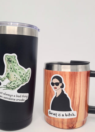Two to-go mugs with snarky grief and encouragement stickers on them. High quality vinyl stickers by Deathday cards